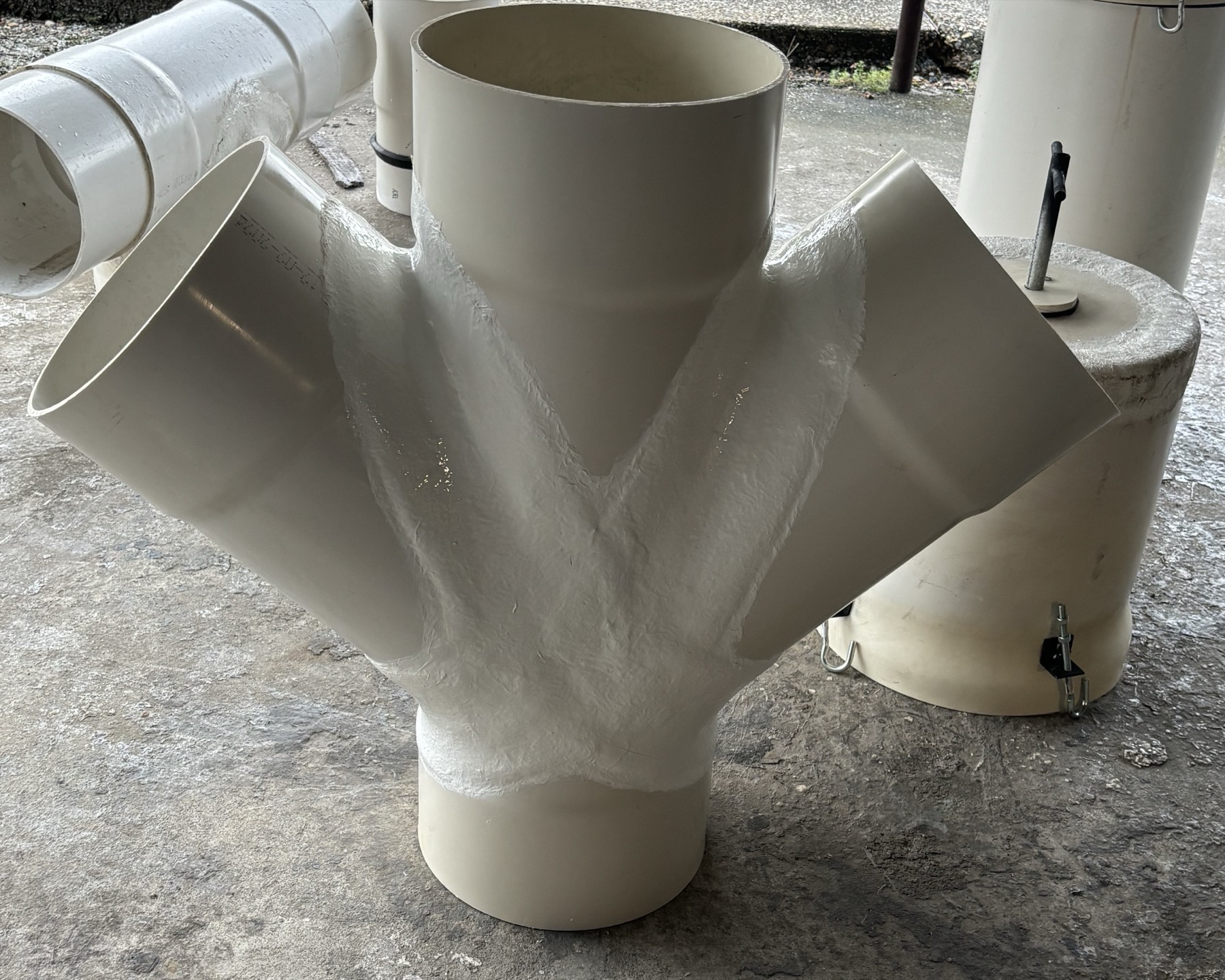 Custom-fabricated four-outlet PVC fitting showing hand-welded seams