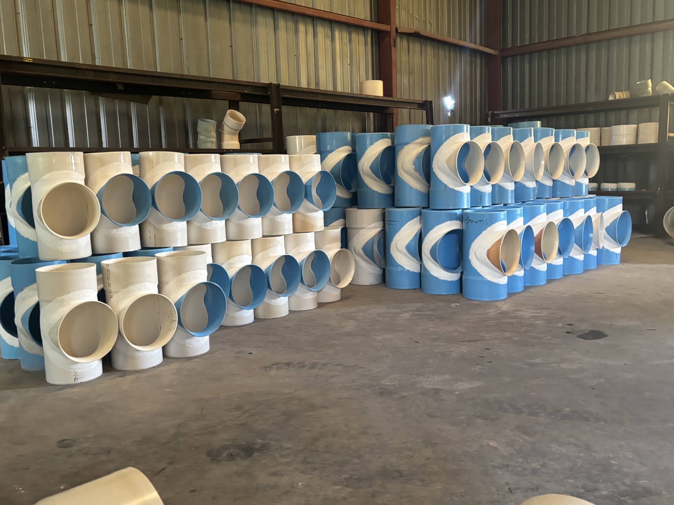 Rows of fabricated PVC tees stacked in the Agri Plastics warehouse