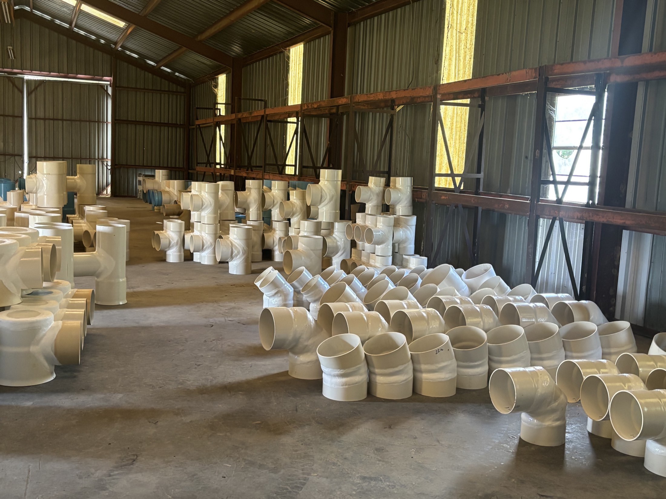 Fabricated PVC fittings lining the Agri Plastics warehouse floor